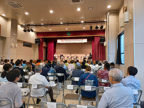 Many participants listening to an explanation in a large hall.