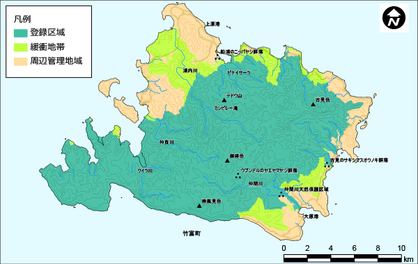 西表島全体の地図。島のほとんどが登録区域を示す深い緑色で塗られている。北と南に緩衝地帯が黄緑色で塗られていて、残りの土地は周辺管理地域としてオレンジ色で塗られている。