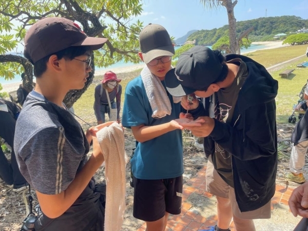 ルーペで生き物を観察する中学生たち